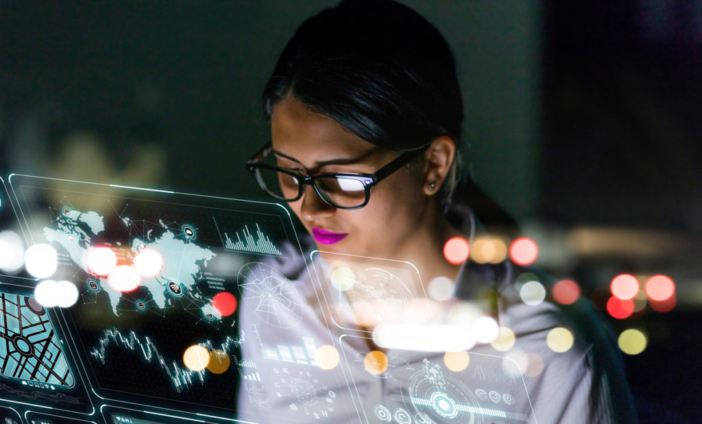 Woman working on computer with city lights