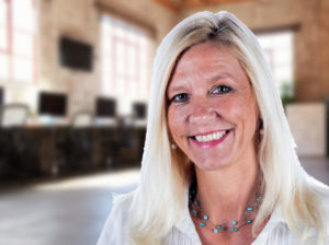 Sabine - portrait of a woman with blonde hair smiling wearing light white shirt